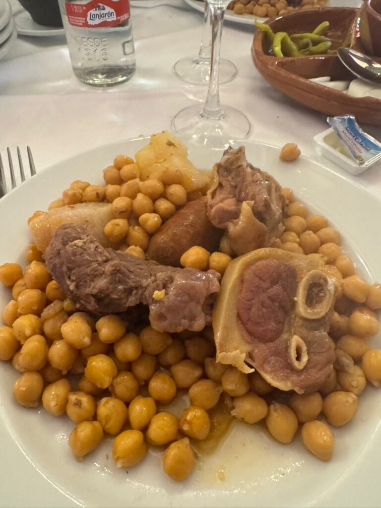 Teller mit Kichererbsen, Fleisch, Chorizo und Markknochen
