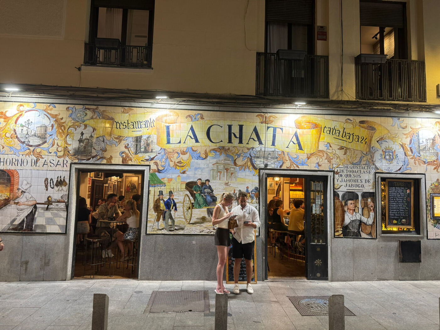 Die gekachelte Fassade der Taberna La Chata bei Nacht