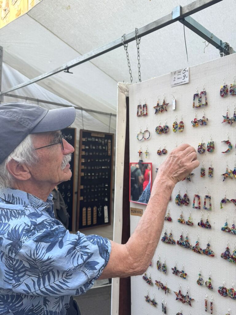 Klaus vor einer Wand mit bunten Ohrringen an einem Stand